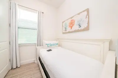 a white bedroom with a bed and a window at Sea Breeze Cottage Near Disney With Margaritaville Resort & Island H20 Waterpark Access - 2982La in Orlando