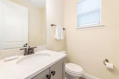 a white bathroom with a sink and a toilet at Ocean Waves Cottage Near Disney With Margaritaville Resort & Island H20 Waterpark Access - 2983La in Orlando