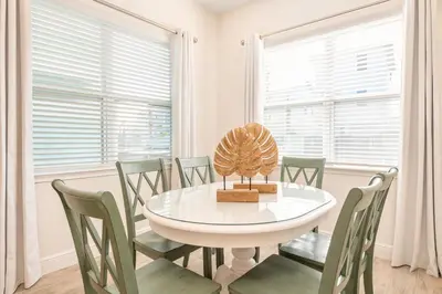 a white dining room with a white table and chairs at Coral Reef Cottage! Near Disney With Margaritaville Resort & Island H2O Access - 8052Ls in Orlando