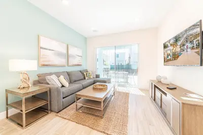 a living room with a couch and a table at Seashell Shore! Near Disney With Margaritaville Resort & Island H2O Access - 8048Ls in Orlando