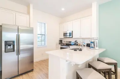 a kitchen with a stainless steel refrigerator at Seashell Shore! Near Disney With Margaritaville Resort & Island H2O Access - 8048Ls in Orlando