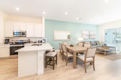 a kitchen and living room with a table and chairs at Seashell Shore! Near Disney With Margaritaville Resort & Island H2O Access - 8048Ls in Orlando