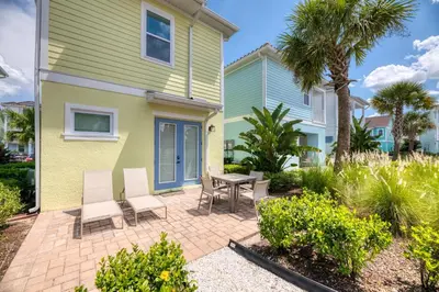 a patio with chairs and a table in front of a house at Smooth Sailing Cottage Near Disney With Margaritaville Resort & Island H20 Waterpark Access - 2978La in Orlando