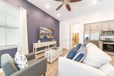 a living room with a couch and a ceiling fan at Sunny Yellow Cottage Near Disney With Margaritaville Resort & Island H2O Access - 3029Sp in Orlando