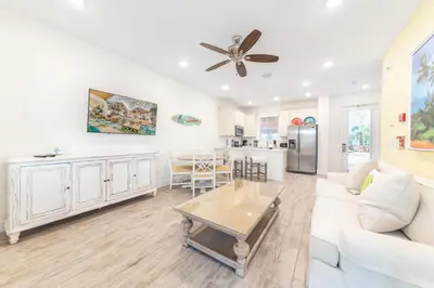 a living room with a white couch and a table at Flip Inn Paradise Cottage With Private Hot Tub Near Disney With Margaritaville Resort & Island H2O Access - 8004Sb in Orlando