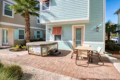 a patio with a table and chairs and a house at Flip Inn Paradise Cottage With Private Hot Tub Near Disney With Margaritaville Resort & Island H2O Access - 8004Sb in Orlando