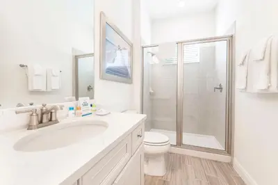 a white bathroom with a sink and a shower at Margarita Beach House Cottage Near Disney With Private Hot Tub & Island H20 Waterpark Access - 3074Pi in Orlando