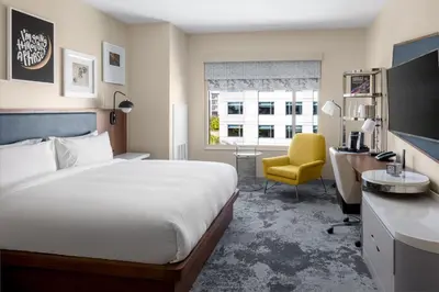 a hotel room with a bed and a desk and a chair at The Celeste Hotel, Orlando, a Tribute Portfolio Hotel in Orlando