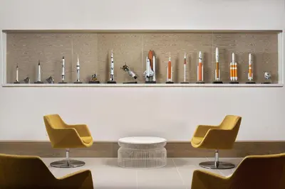 a room with two chairs and a table and a shelf with guns at The Celeste Hotel, Orlando, a Tribute Portfolio Hotel in Orlando