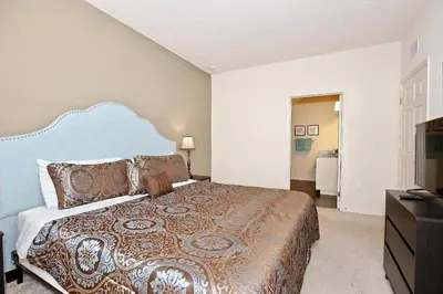 a bedroom with a large bed and a television at Great townhouse in gated community West Lucaya in Kissimmee