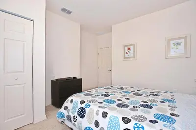 a bedroom with a bed with a blue and white comforter at Great townhouse in gated community West Lucaya in Kissimmee