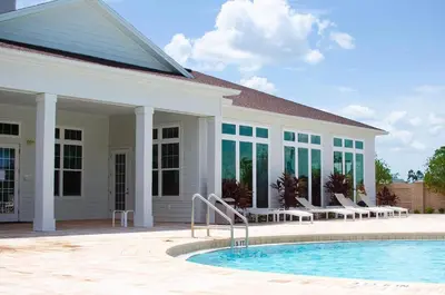 a house with a swimming pool in front of a building at Great townhouse in gated community West Lucaya in Kissimmee