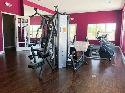a gym with tread machines in a room with red walls at Great townhouse in gated community West Lucaya in Kissimmee