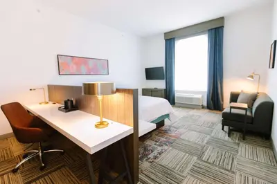 a hotel room with a bed and a desk with a lamp at Hilton Garden Inn Winter Park, FL in Orlando