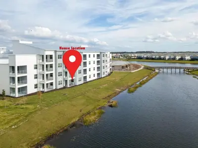 a building with a red sign next to a river at Marvelous 2 Bd Apt Close to Disney at Storey Lake 106 in Kissimmee