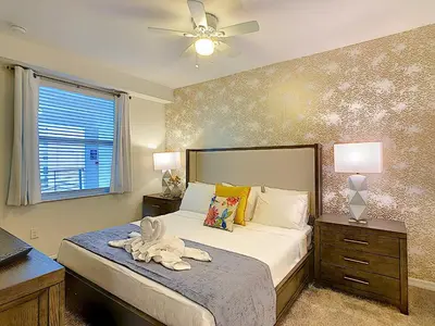 a bedroom with a bed and a ceiling fan at Fabulous Thematic 2BR Condo with Kids Splash Pad in Kissimmee