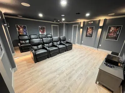 a waiting room with black leather chairs and a table at Mickeys Circle - Gorgeous! Modern 6BR, with Private South Facing Pool Hot Tub BBQ Theater 2 Miles to Disney in Orlando