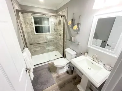 a bathroom with a toilet and a sink and a shower at Mickeys Circle - Gorgeous! Modern 6BR, with Private South Facing Pool Hot Tub BBQ Theater 2 Miles to Disney in Orlando