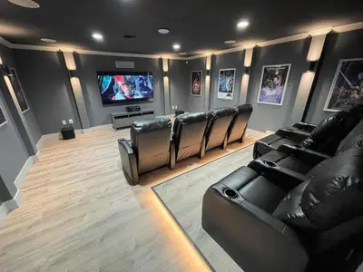 a movie room with leather chairs and a flat screen tv at Mickeys Circle - Gorgeous! Modern 6BR, with Private South Facing Pool Hot Tub BBQ Theater 2 Miles to Disney in Orlando