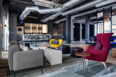 a lobby with chairs and tables and a bar at Aloft Orlando Lake Buena Vista in Orlando