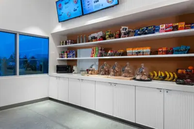 a kitchen with white cabinets and shelves with food at Aloft Orlando Lake Buena Vista in Orlando