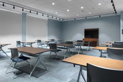 a conference room with tables and chairs and a screen at Aloft Orlando Lake Buena Vista in Orlando