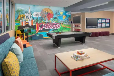a childrens playroom with a pool table in front of a mural at Tru By Hilton Orlando Convention Center in Orlando