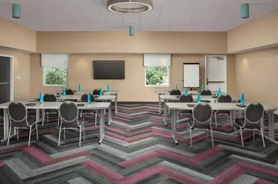 a conference room with tables and chairs and a screen at Tru By Hilton Orlando Convention Center in Orlando