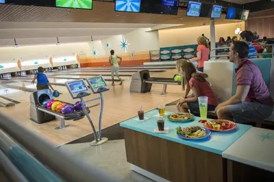 a group of people sitting at a bowling alley at Universal's Cabana Bay Beach Resort in Orlando