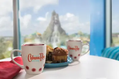 a table with two coffee cups and a plate of food at Universal's Cabana Bay Beach Resort in Orlando