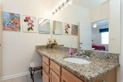 a bathroom with a sink and a large mirror at Beautiful Condo - Windsor Hills - 2 Miles Disney in Orlando