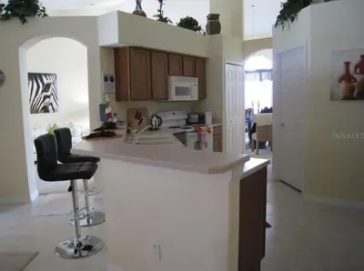 a kitchen with a counter and a black chair at Family Vacation Home With Pool and Spa Near Disney and Universal in Orlando