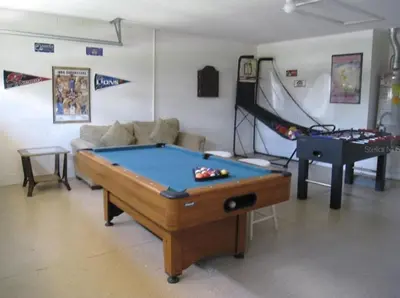a living room with a pool table and a couch at Family Vacation Home With Pool and Spa Near Disney and Universal in Orlando