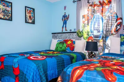 two beds in a room with a superhero mural at Gorgeous Four Bd w/ Pool close to Disney 5035 in Kissimmee