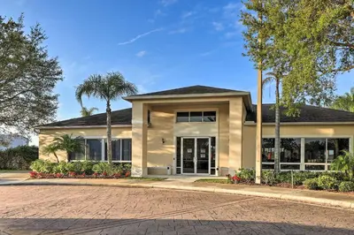 a house with a palm tree in front of it at Kissimmee Condo with Resort Perks - 5 Mi to Disney! in Orlando