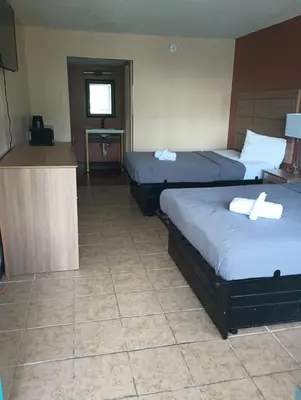 a hotel room with two beds and a kitchen at Altamonte Springs Hotel and Suites in Orlando