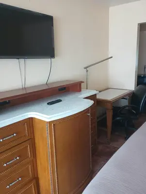 a hotel room with a desk and a flat screen tv at Altamonte Springs Hotel and Suites in Orlando
