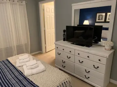 a bedroom with a white dresser with a television on it at Terra Verde Vacation Rentals in Kissimmee