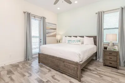 a bedroom with a large bed and two windows at The Tiki Room - Beautiful Two Bedroom Cottage Near Disney With Margaritaville Resort & Island H20 Waterpark Access - 2954Sr in Orlando