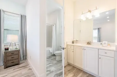a white bathroom with a sink and a toilet at The Tiki Room - Beautiful Two Bedroom Cottage Near Disney With Margaritaville Resort & Island H20 Waterpark Access - 2954Sr in Orlando