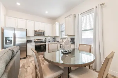 a kitchen with a glass table and chairs in a room at The Tiki Room - Beautiful Two Bedroom Cottage Near Disney With Margaritaville Resort & Island H20 Waterpark Access - 2954Sr in Orlando