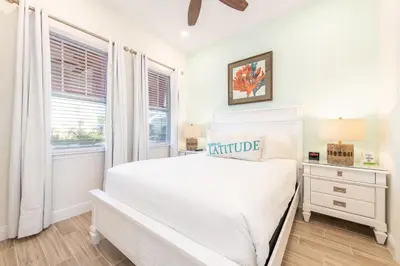 a white bedroom with a bed and a window at Lake View Cottage With Private Pool Near Disney And Margaritaville Resort & Island H2O Access - 8089Su in Orlando