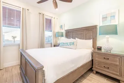a bedroom with a large bed and two windows at Lake View Cottage With Private Pool Near Disney And Margaritaville Resort & Island H2O Access - 8089Su in Orlando