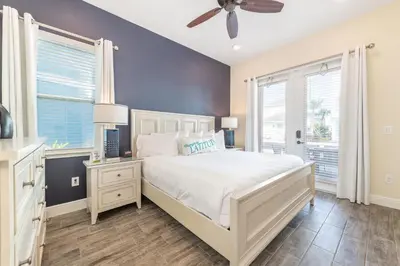 a bedroom with a white bed and a ceiling fan at Sandy Shores Cottage Near Disney With Margaritaville Resort & Island H2O Access - 8077Kd in Orlando