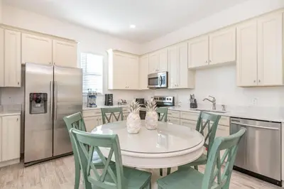 a kitchen with a table and chairs and a refrigerator at Life Is Good Cottage Near Disney With Margaritaville Resort & Island H2O Access - 8059Kd in Orlando