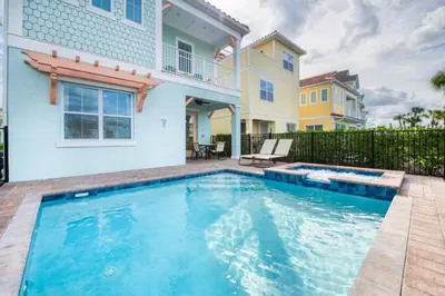 a swimming pool in front of a house at A Wave From It All Cottage With Private Pool Near Disney And Margaritaville Resort & Island H2O Access - 8039Su in Orlando