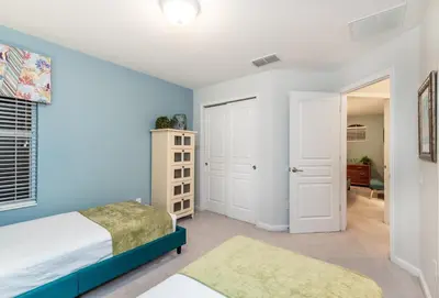 a bedroom with blue walls and a bed and a door at Spacious Home wPrivate PoolSpa & FREE Waterpark in Orlando