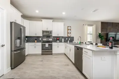 a kitchen with white cabinets and stainless steel appliances at 2911 Fable Street in Kissimmee