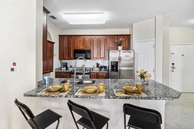 a kitchen with a island with chairs and a counter top at First floor Vista Cay Condo wFREE Resort Access in Orlando