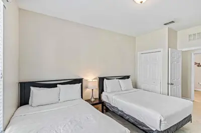 two beds in a room with white walls at First floor Vista Cay Condo wFREE Resort Access in Orlando